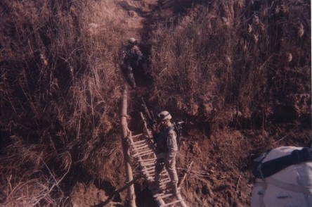The boys walk over a precarious bridge while on patrol