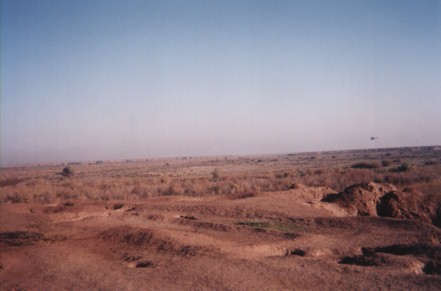helicopter on patrol with shell craters in the foreground